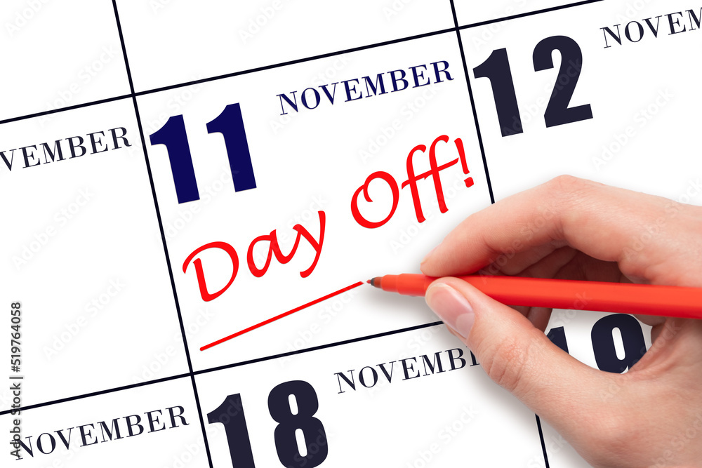 Hand writing text DAY OFF and drawing a line on calendar date 11 November. Vacation planning concept. Hand writing text DAY OFF and drawing a line on calendar date 11 November. Vacation planning concept.