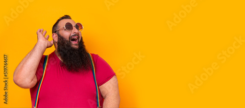 Big funny bearded gay man wearing sunglasses and a happy surprise expression 
