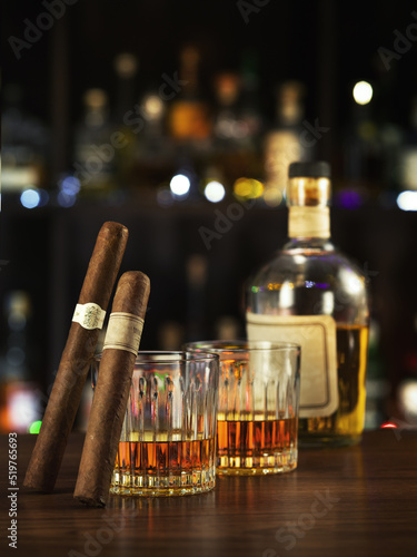 NO LOGOS OR TRADEMARKS!  SELF MADE LABELS! close up view of cigar, bottle of whiskey and a glasses aside on color back.