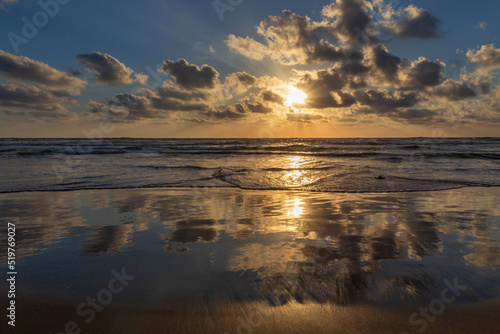 Sunset on the Mediterranean coast. Natural landscape. Mediterranean nature. Reflection, beautiful clouds, blue sky and yellow sunlight. Israel. © Zoya El
