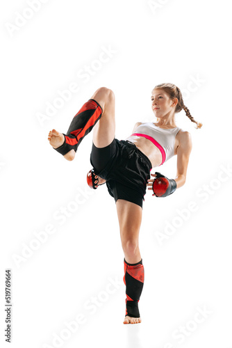 Junior female MMA fighter in sports uniform and gloves training isolated on white background. Concept of sport, competition, action, healthy lifestyle.
