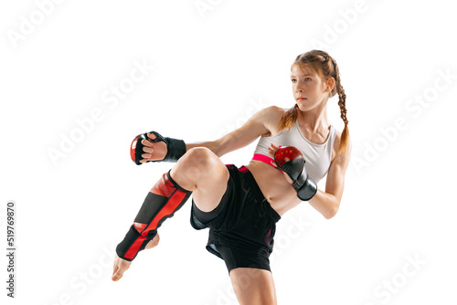 Junior female MMA fighter in sports uniform and gloves training isolated on white background. Concept of sport, competition, action, healthy lifestyle.