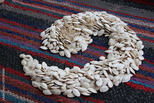 Heap of pumpkin seeds on an old carpet.