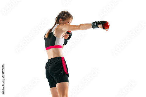 Junior female MMA fighter in sports uniform and gloves training isolated on white background. Concept of sport, competition, action, healthy lifestyle. © master1305