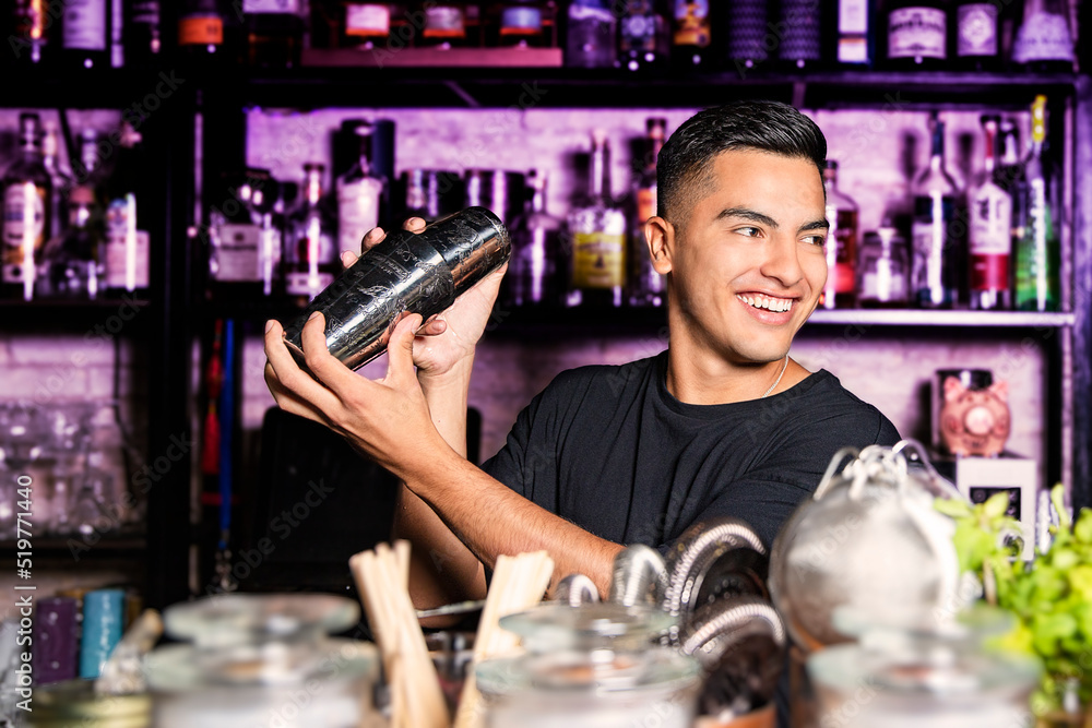 bartender with a shaker in his hands smile looking to the side at a nightclub bar bartender with a shaker in his hands smile looking to the side at a nightclub bar