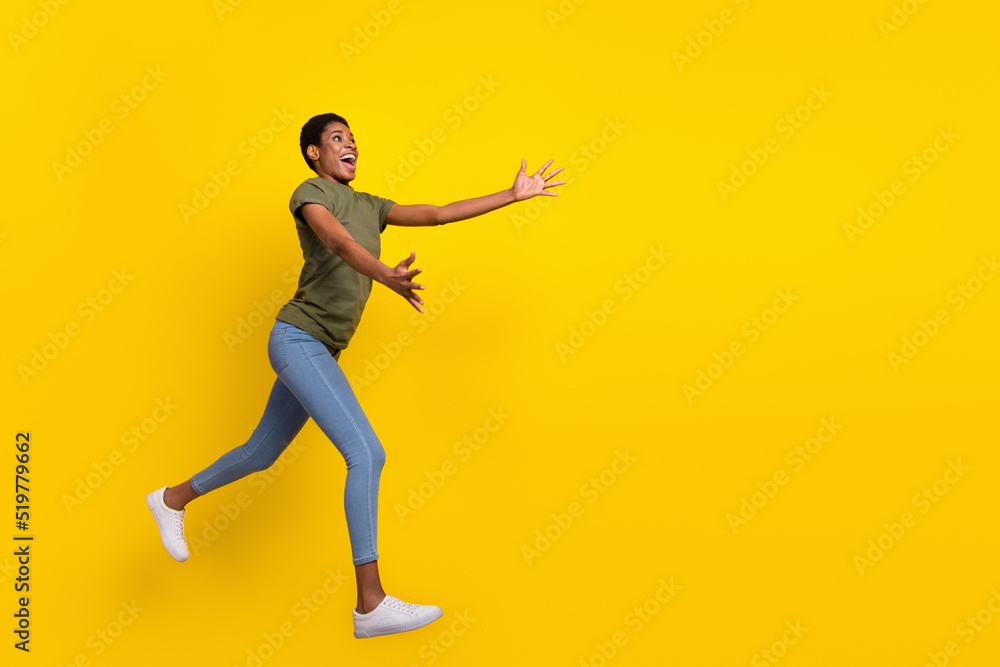 Full length photo of funky excited person jump opened arms catch expect empty space isolated on yellow color background