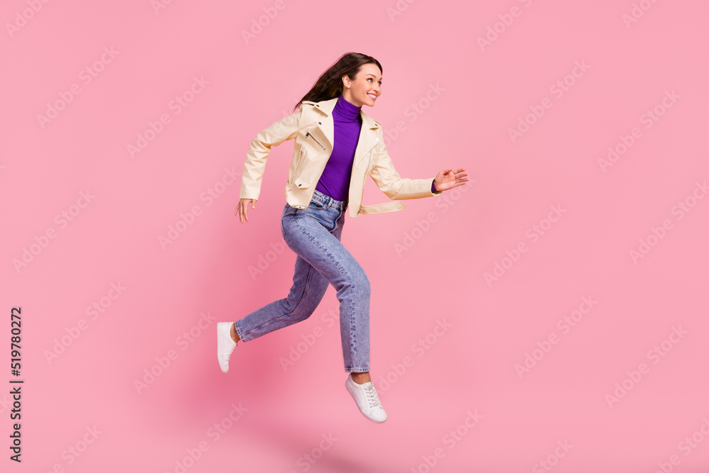 Full body photo of pretty brunette lady run wear jacket jeans sneakers isolated on pink color background