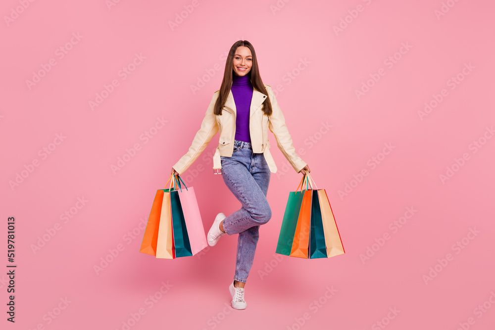 Full length photo of cute brunette young lady buy stuff wear trendy cloth sneakers isolated on pink color background
