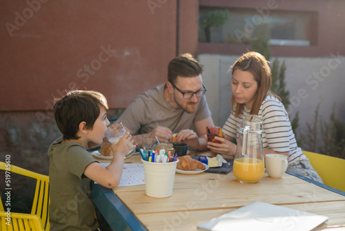 family with on child having breakfast outdoor in homebackyard photo