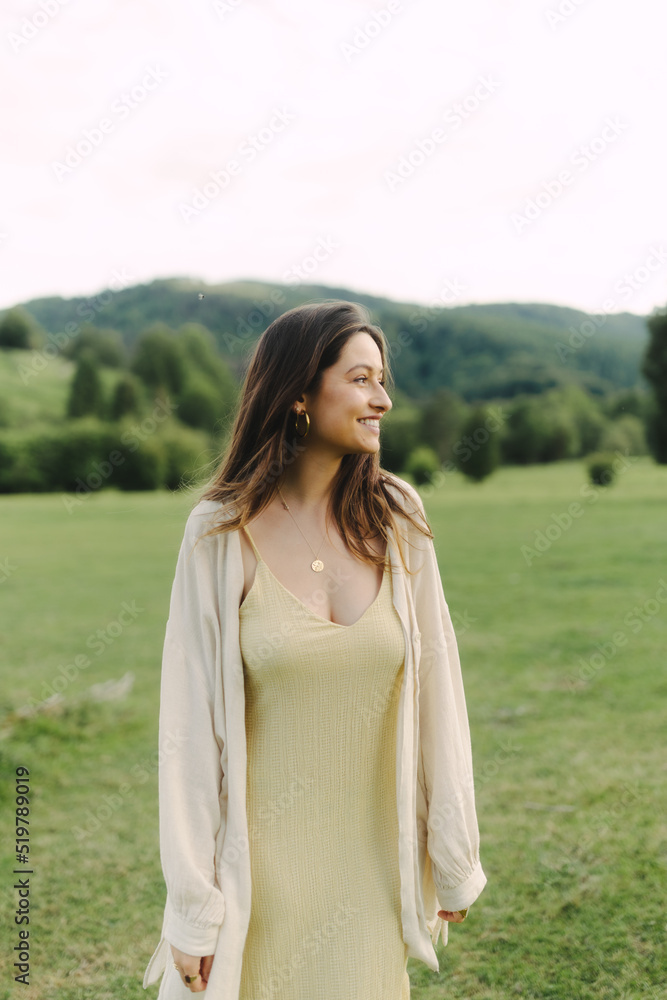 Young smiling woman standing in field in summer Young smiling woman standing in field in summer
