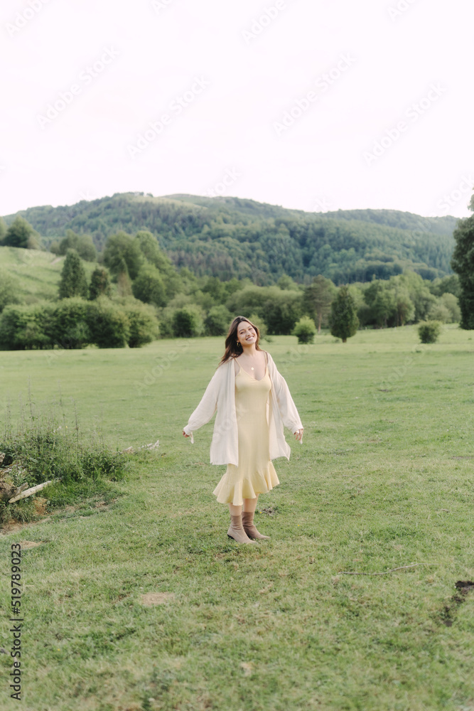 Young smiling woman standing in field in summer Young smiling woman standing in field in summer