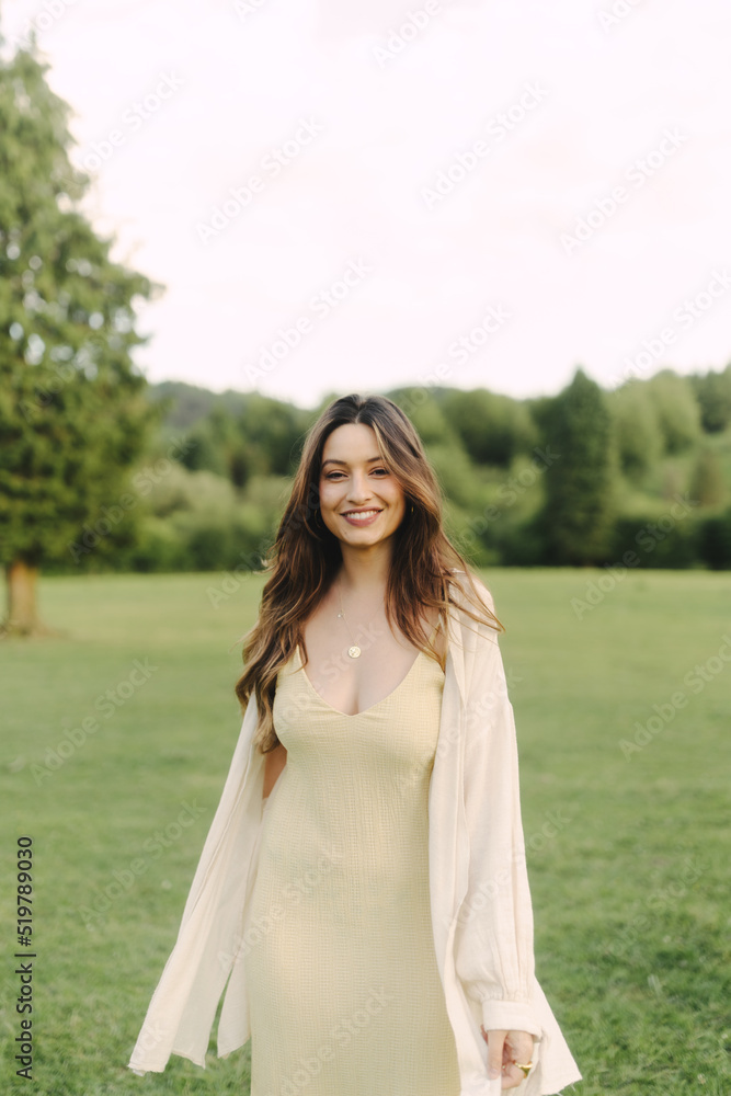 Young smiling woman standing in field in summer Young smiling woman standing in field in summer