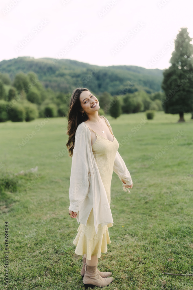 Young smiling woman standing in field in summer Young smiling woman standing in field in summer