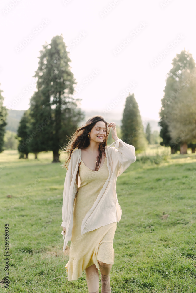 Young smiling woman standing in field in summer Young smiling woman standing in field in summer