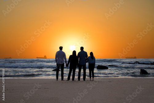 Family silhouette on the beach at sunrise