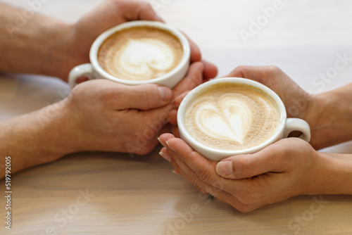 Couple drinking coffee in a cafe man and woman with a cup of hot latte. Selective focus.