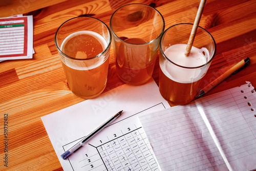 The pub quiz concept. Beer glass and blank paper for answers. photo