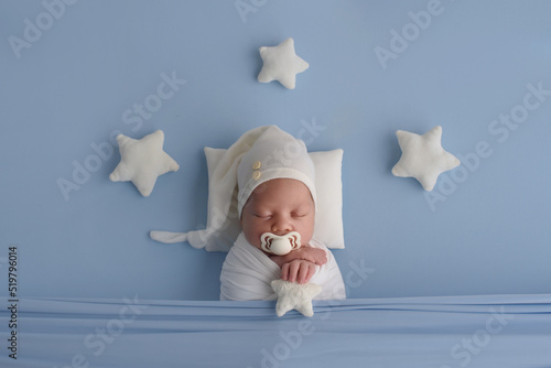 A cute newborn is lying in bed. baby sleep with the stars