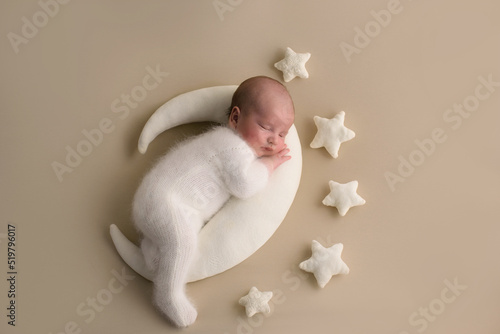 A cute newborn is lying in bed. baby sleep with the stars