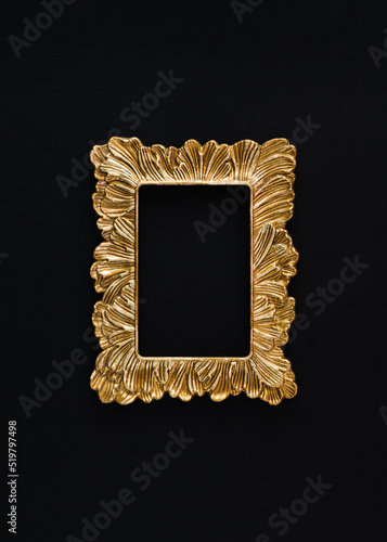 A creative arrangement made of a retro gold frame on a black background. Minimal flat lay concept with copy space.