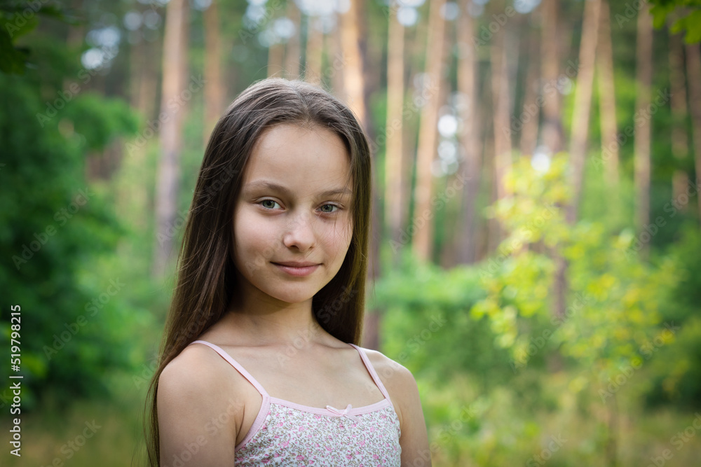 Portrait of beautiful preteen smiling girl in forest with pine-trees on summer sunset day Portrait of beautiful preteen smiling girl in forest with pine-trees on summer sunset day
