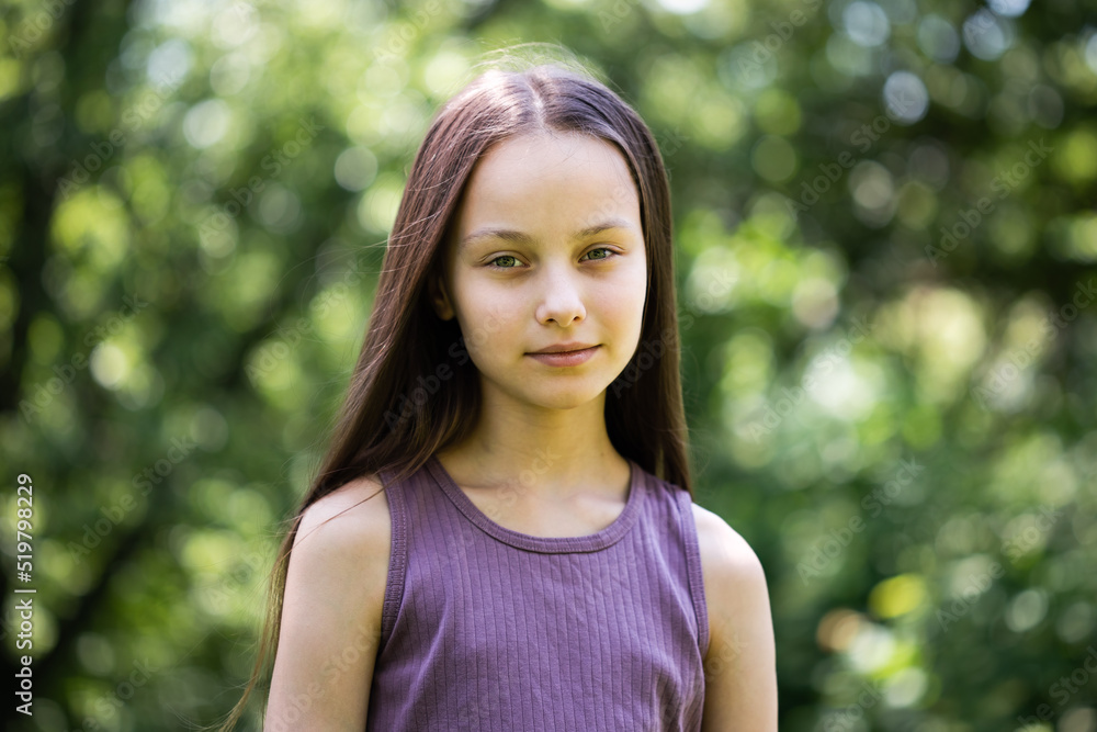 Portrait of beautiful preteen smiling girl in forest on summer sunny day Portrait of beautiful preteen smiling girl in forest on summer sunny day