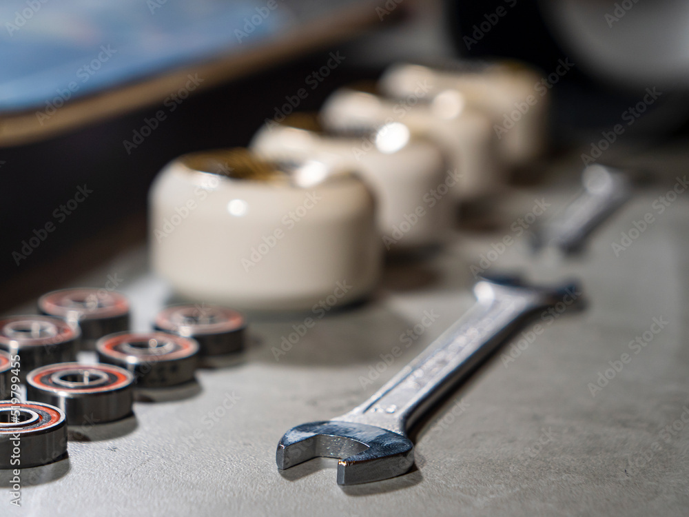 CLOSE UP: Wrench lined up with skateboard wheels and bearings on working desk CLOSE UP: Wrench lined up with skateboard wheels and bearings on working desk