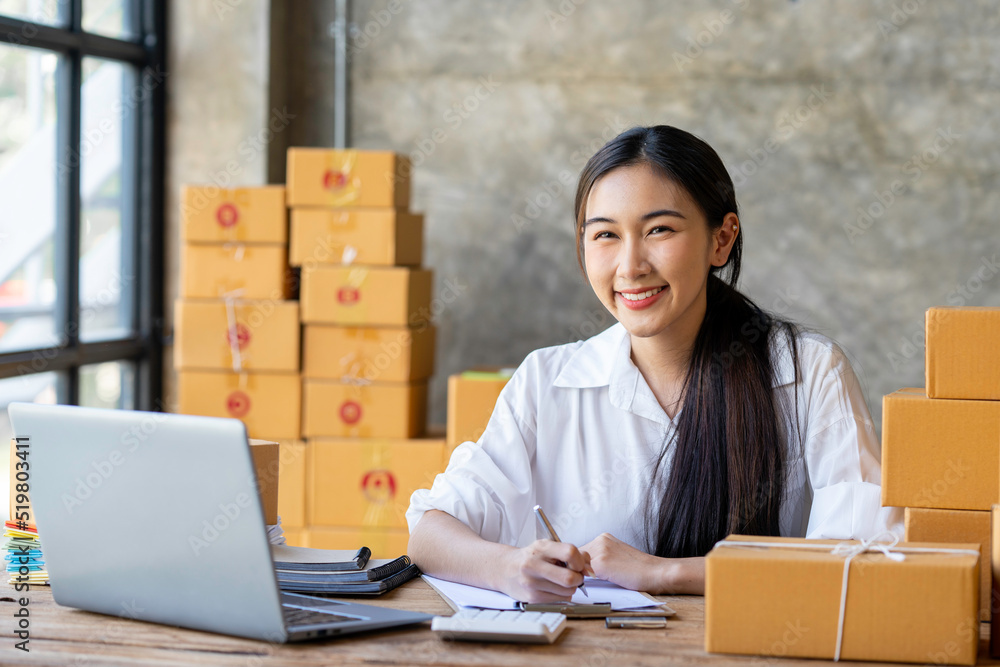 Young Asian business woman startup sme small business entrepreneur SME distribution warehouse with parcel mail box. SME Online marketing and product packaging and delivery service. Young Asian business woman startup sme small business entrepreneur SME distribution warehouse with parcel mail box. SME Online marketing and product packaging and delivery service.