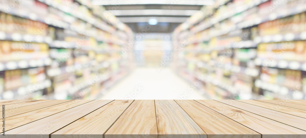 Wood table top with supermarket grocery store aisle interior blurred background with bokeh light for product display