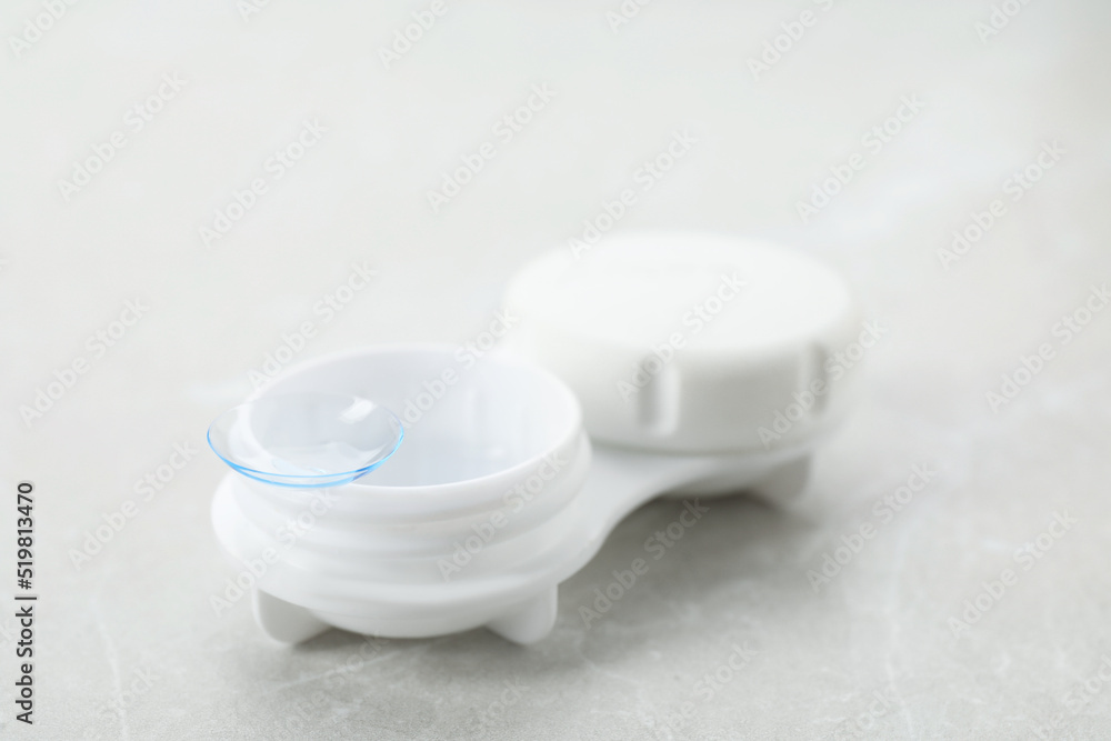 Case with contact lens on light grey table, closeup Case with contact lens on light grey table, closeup