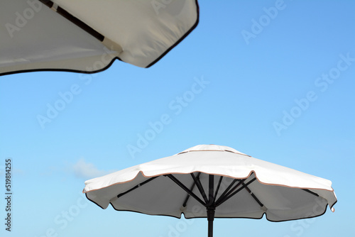 Beautiful white beach umbrellas against blue sky
