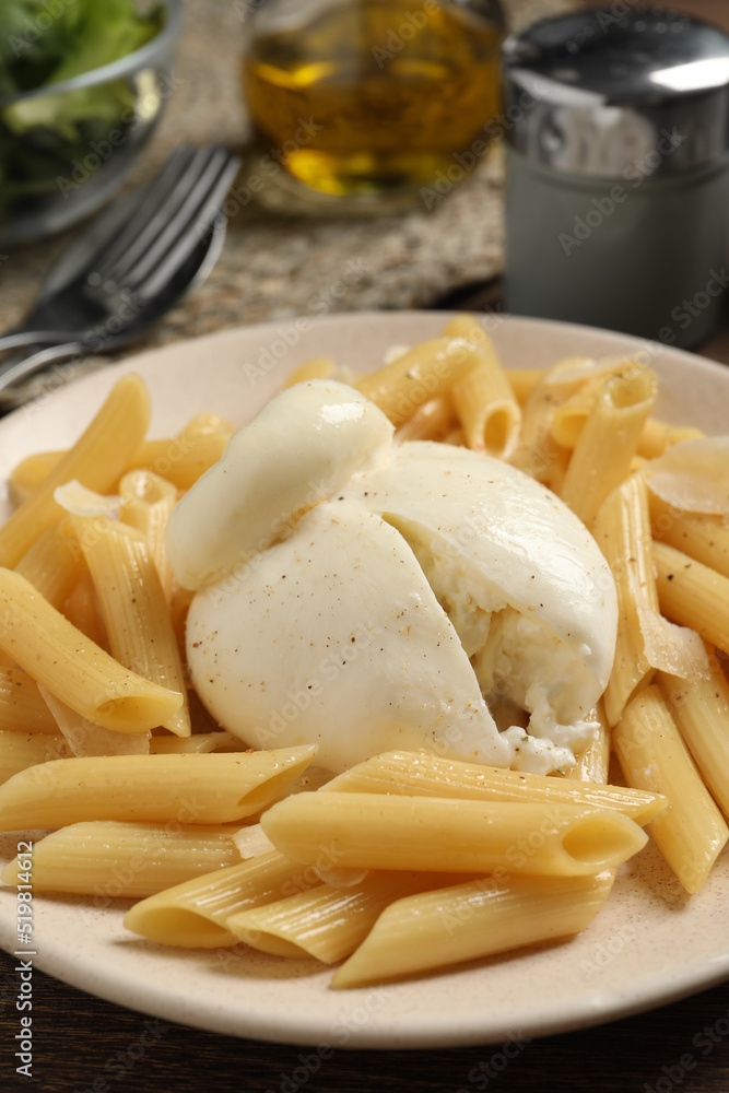 Plate of delicious pasta with burrata on wooden table, closeup Plate of delicious pasta with burrata on wooden table, closeup