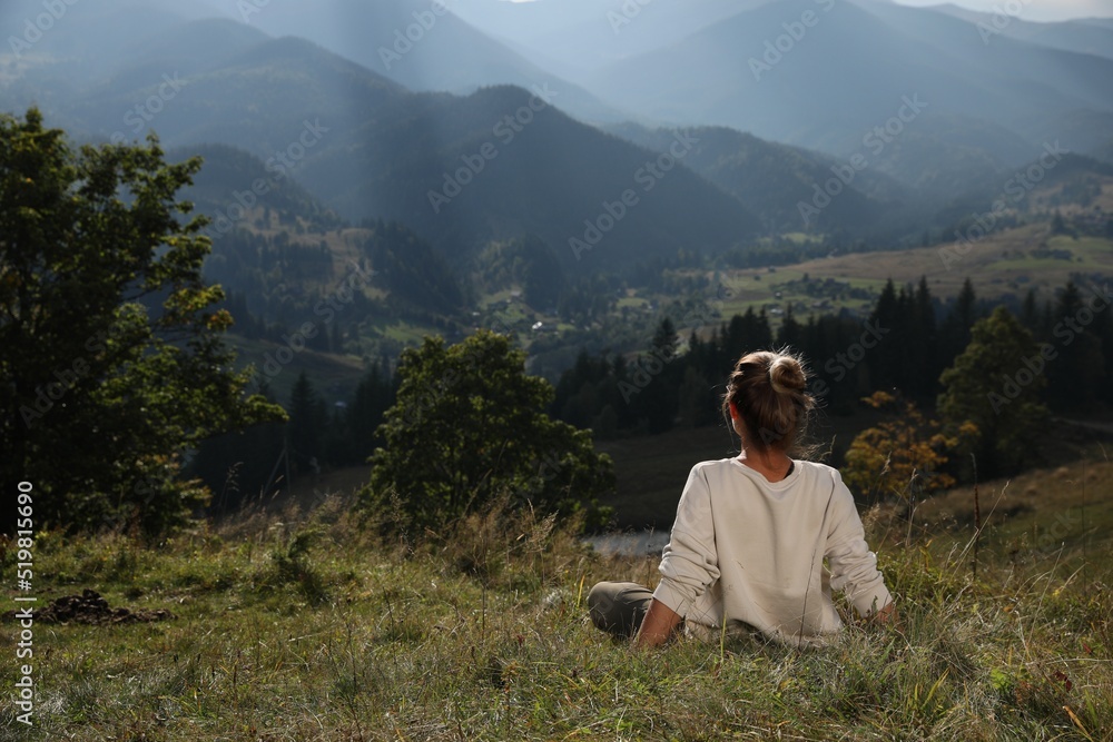 Woman enjoying beautiful mountain landscape, back view. Space for text