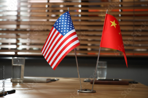 USA and China flags on wooden table in office. International relations photo