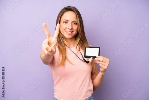 pretty caucasian woman smiling and looking friendly, showing number two. vip pass id card concept photo