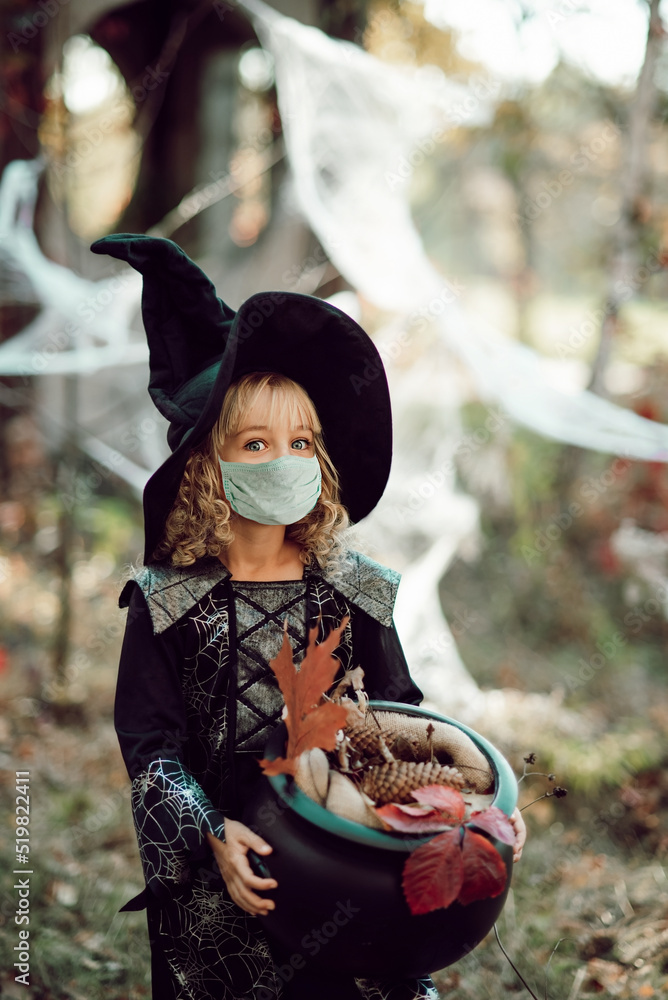 Happy Halloween on quarantine coronavirus pandemic. social distance. Child Girl in witch