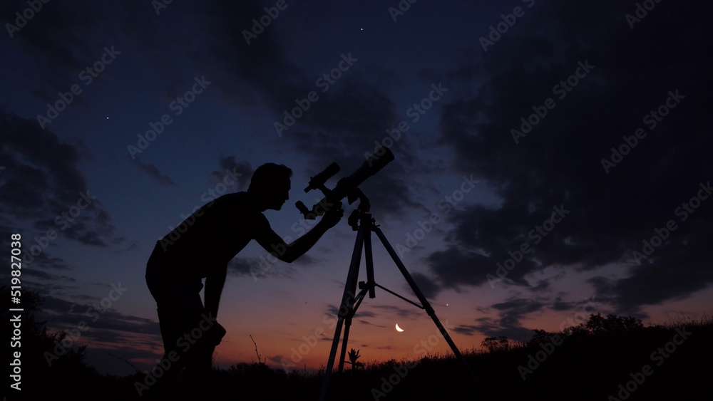 Man with astronomical telescope observing night sky, under the Milky way stars.