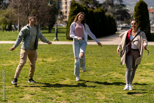 Dancing and jumping group of diverse friends on lawn