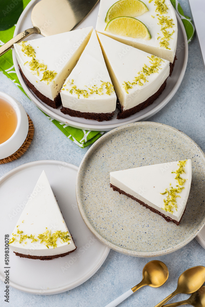 Fresh no-bake cheesecake with lime, mascarpone, whipped cream on a white stone background on white plate, top view