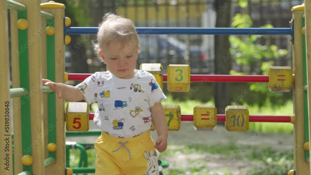 Mother with little cute child playing on outdoor playground, kid play on kindergarten yard on sunny day. Active 1.5 year old toddler. Healthy summer activity for children. Mother with little cute child playing on outdoor playground, kid play on kindergarten yard on sunny day. Active 1.5 year old toddler. Healthy summer activity for children.