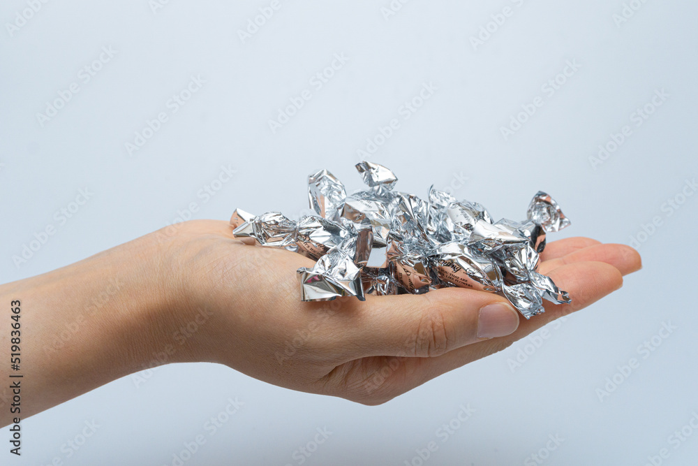 Hands full of candies in silver shells Hands full of candies in silver shells