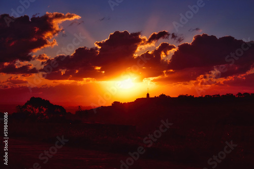 Dramatic sunset scene over hills in the countryside with deep shades of orange  red and blue