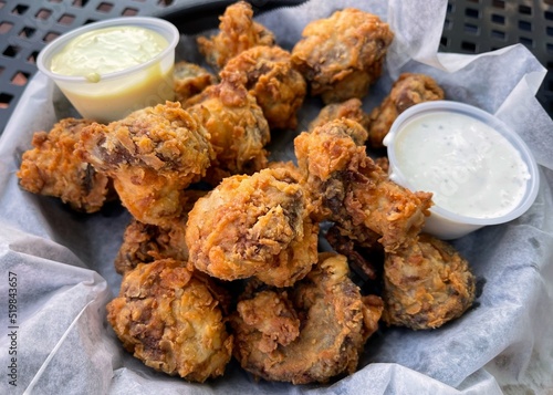 Fried mushroom appetizer in a basket with ranch and horseradish sauces