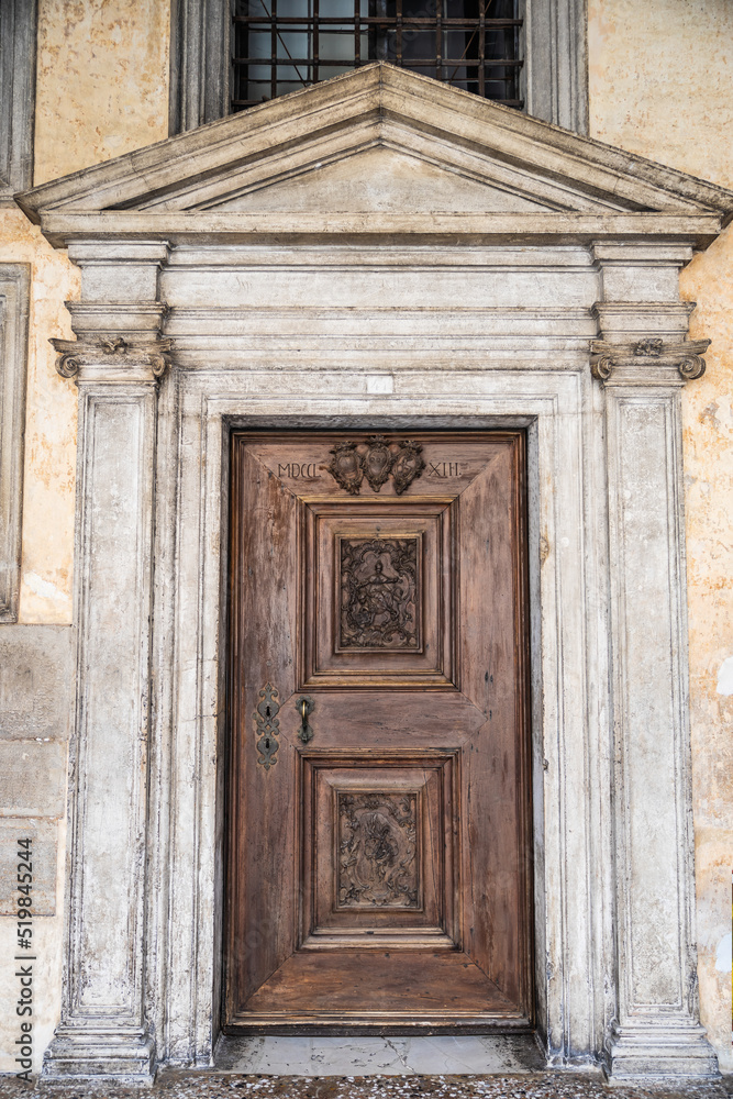 An old, weathered wooden door with an artistic frame in Venice.