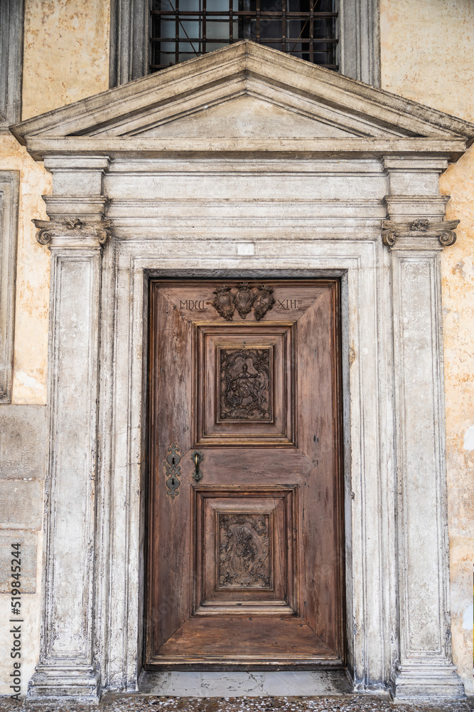 An old, weathered wooden door with an artistic frame in Venice. An old, weathered wooden door with an artistic frame in Venice.