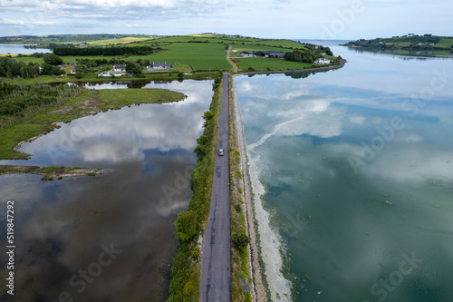 Fototapeta Drone aerial seascape of empty straight road crossing the sea