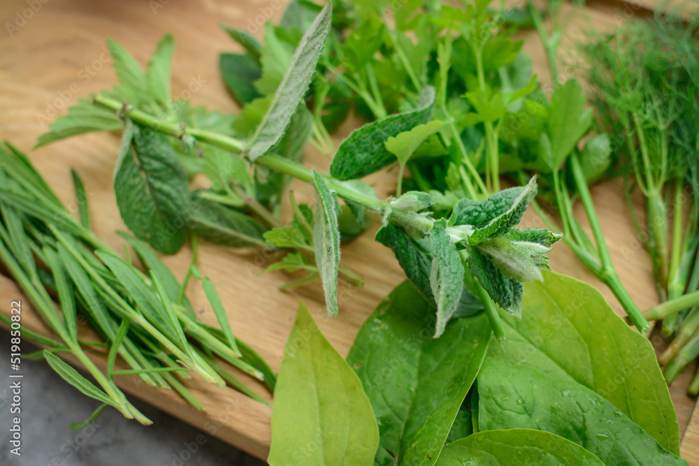 Various herbs picked from the garden, getting ready for drying, on wooden background Various herbs picked from the garden, getting ready for drying, on wooden background