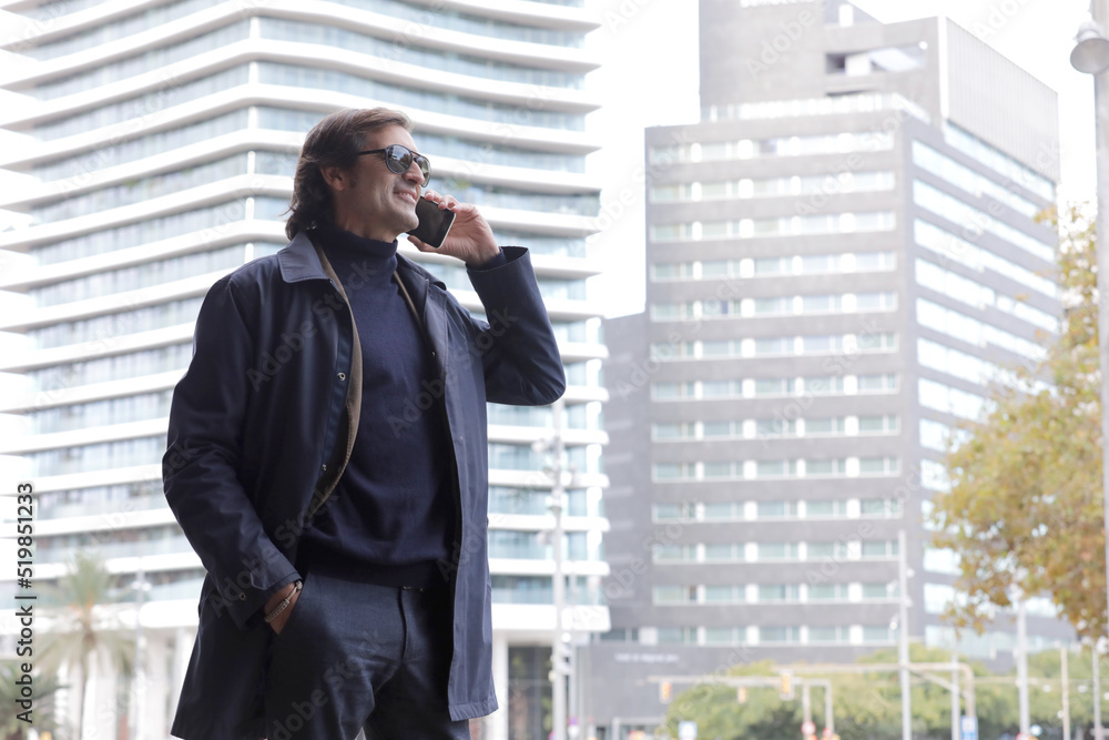 happy businessman walking outdoors with mobile phone. happy businessman walking outdoors with mobile phone.