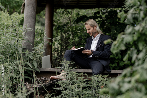 Geschäftsmann arbeitet auf einem laptop im Freien auf einen Holzsteg