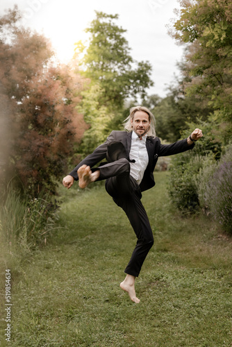 Geschäftsmann voller Energie barfuß im Garten